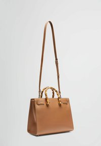 Borsa a mano in pelle marrone con una forma strutturata, manico in stile bambù e tracolla regolabile. Texture liscia e design minimalista.