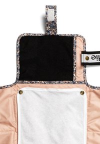 En tygorganisatör med blommönster har en svart övre del, en beige nedre del och ett vitt handdukselement med tryckknappslås.