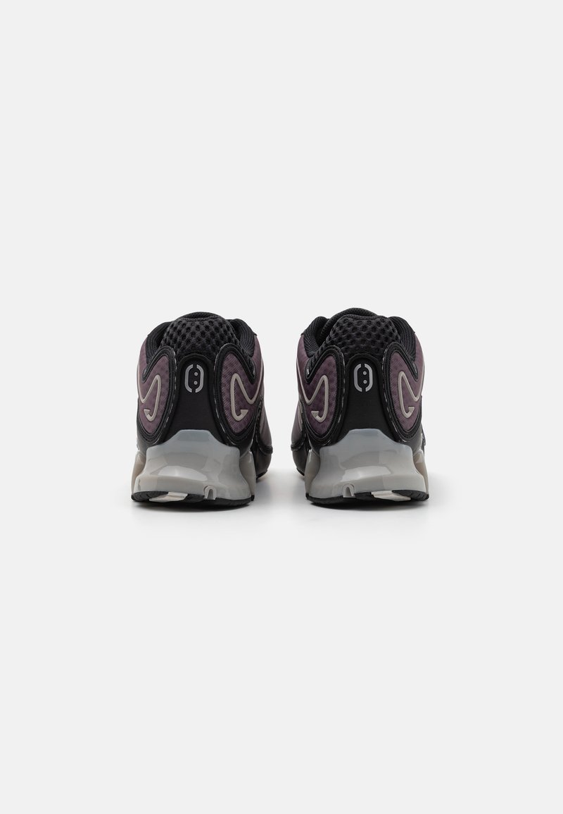Czarne i fioletowe sneakersy z siateczkowego materiału, z zakrzywionymi akcentami i szarym podbiciem. Oferują zaokrąglony obcas oraz teksturowany wzór na górnej części.