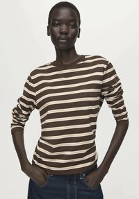 Dugotrajna majica na pruge u smeđoj i krem boji s okruglim izrezom, izrađena od mekanog materijala, s podvrnutim rukavima i ležernim krojem.