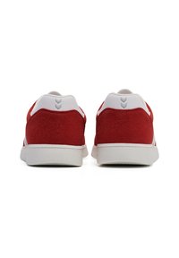 Red suede sneakers with white accents and grey logo on the heel. Features a low profile and rubber sole. Simple, clean design.