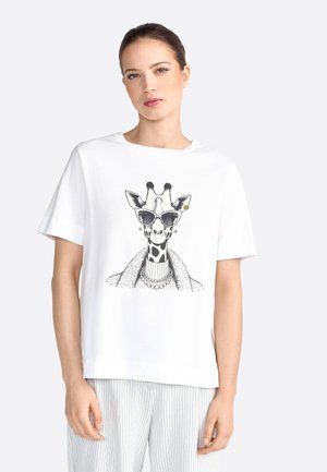 T-shirt en coton blanc avec une illustration en noir et blanc d'une girafe portant des lunettes de soleil, agrémentée d'accessoires décoratifs et de textures à motifs.