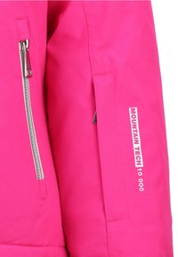Roze skijas met een gladde textuur, zilveren rits en het label "MOUNTAIN TECH 10.000" op de linkermouw.