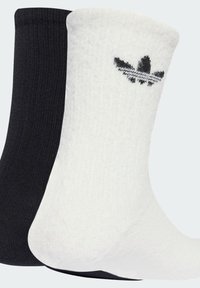 Crew socks in black and white, featuring ribbed texture, contrasting colors, and an Adidas logo in black on the white sock.