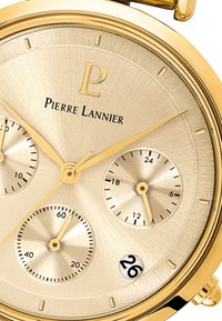 Quadrante dell'orologio dorato con texture spazzolata. Presenta tre sottoquadranti, lancette dorate e display della data. Logo del marchio "Pierre Lannier" visibile.