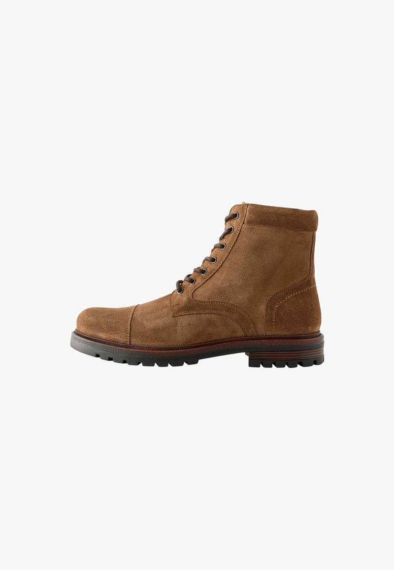 Brązowe zamszowe botki za kostkę z zaokrąglonym noskiem, sześcioma dziurkami na sznurowadła oraz teksturowaną gumową podeszwą. Posiadają przeszywane akcenty oraz wyściółkę w okolicy kostki.