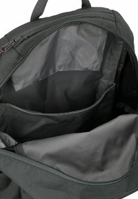 Zaino nero con il vano principale aperto che mostra una manica imbottita per laptop e una tasca interna più piccola.