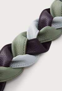 Vihreä, tummanvihreä ja violetti punottu nahkavyö. Rakeinen pinta, jossa näkyvät saumat. Litteä muotoilu, sopii arkikäyttöön.