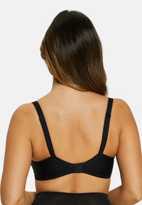 Sujetador negro con tirantes ajustables y cierre de gancho. Material suave y liso con diseño minimalista y sin patrones o detalles visibles.