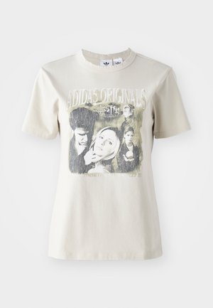 Bežs kokvilnas T-krekls ar apaļu dekoltē. Satur grafisko attēlu ar varoņiem un tekstu no "Buffy", melnā un pelēkā krāsā.