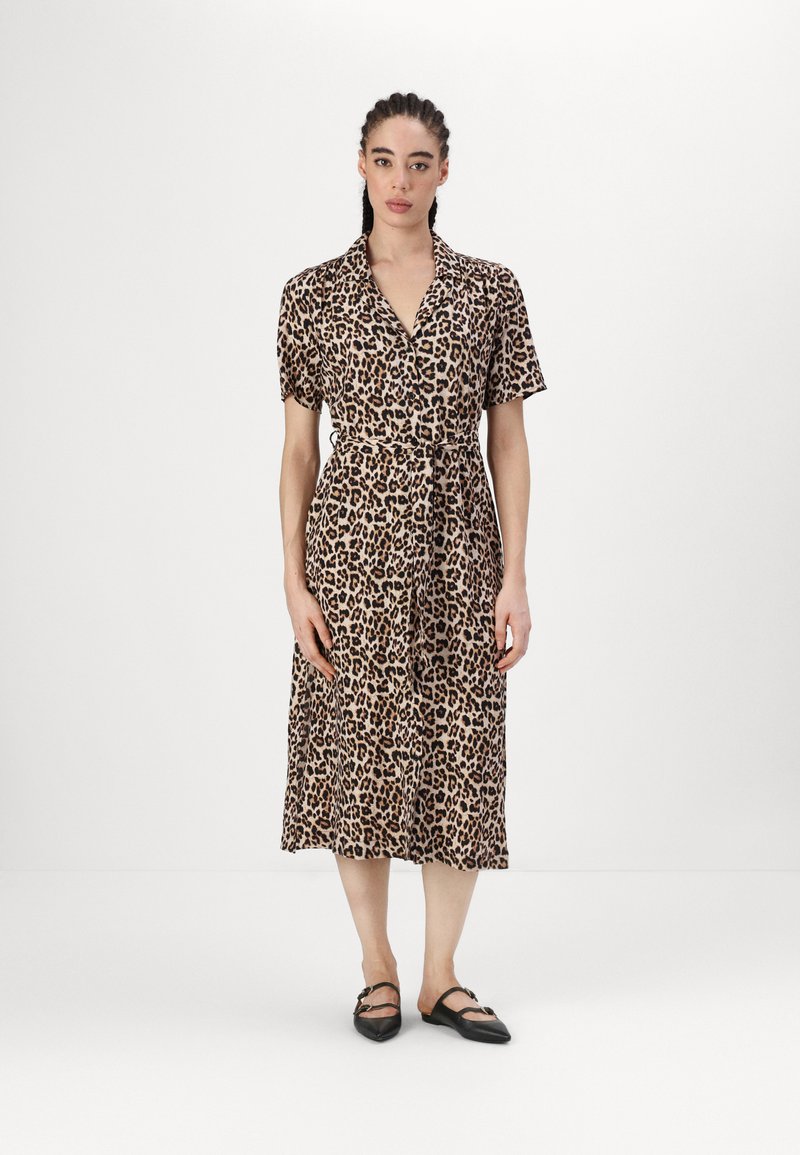 Leopardų rašto trumpomis rankovėmis su apykakle, juosmens juosta ir vidutinio ilgio sijonu. Minkšta medžiaga su lygiu paviršiumi. Juodos plokščios bateliai.