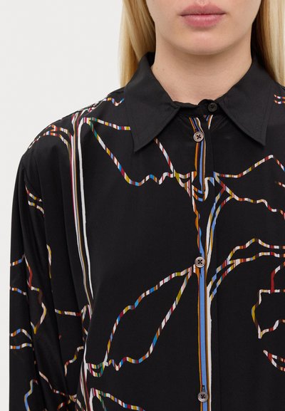 Čierna košeľa s golierom na gombíky, zdobená viacfarebnými abstraktnými pruhmi. Vyrobená z hladkej tkaniny s voľným strihom.