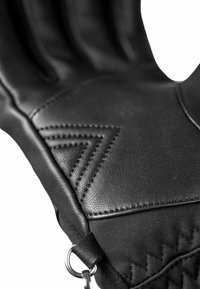 Black leather glove with stitched accents, featuring a textured surface and angular patterns. Includes a metal ring at the wrist for attachment.