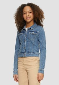 Leren denim jack in lichtblauw, met een knoopsluiting aan de voorkant, twee borstzakken en lange mouwen met lichtblauwe stikselaccenten.
