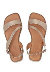 Gouden sandalen met een platte zool, met een vierkante neus, een kruisbandontwerp en een gespaccent op de enkelband.