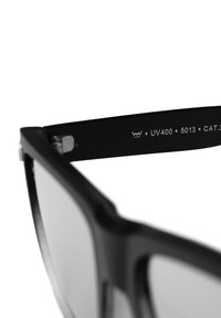 Černé sluneční brýle s matným povrchem, obdélníkový tvar, UV400 ochrana, modelové číslo 5013 a kovový detail na pantě.