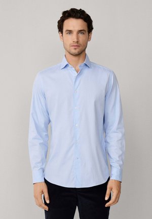 Camicia azzurra a maniche lunghe con bottoni, realizzata in tessuto morbido, caratterizzata da un colletto a punta, orlo dritto e patta con bottoni.