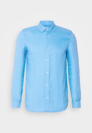 Chemise bleu clair à manches longues et à boutons, en tissu texturé. Présente un col classique et des boutons blancs sur le devant et aux poignets.