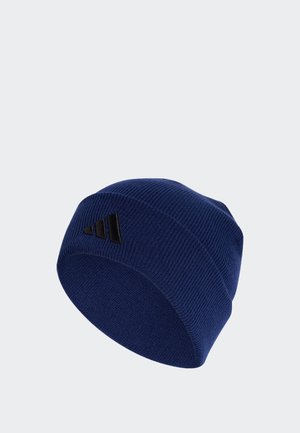 Bonnet en maille côtelée bleu marine, avec un revers et un petit logo noir, présenté sur un fond clair uni.