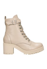 Stivaletti in pelle beige alla caviglia con un tacco spesso, allacciatura frontale, hardware in metallo e una suola piatta testurizzata caratterizzata da un design intrecciato.