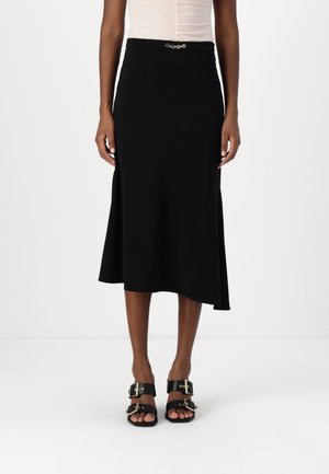 Svart midi skjørt med tilpasset midje, asymmetrisk kant og gullfarge detaljer. Glatt stoff med en subtil glans. Brukes med svarte sandaler.