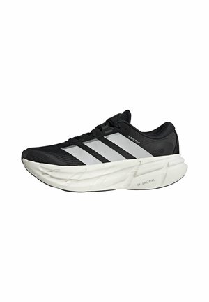 Chaussure de course Adidas noire et blanche avec une semelle blanche épaisse, trois bandes blanches sur le côté et un marquage "Adistar" et "Dreamstrike".