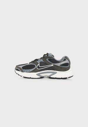 Sivá a čierna bežecká obuv Nike s bielou podrážkou a logom Swoosh, s panelmi z sieťoviny a semišu, pohľad z vonkajšej strany.