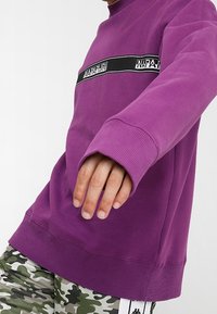 Paarse sweatshirt van katoen, met een geribbelde ronde hals en boorden. Zwarte merklogo-streep over de borst. Casual pasvorm.