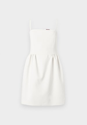 Abito bianco senza maniche con sottili spalline, corpetto aderente e gonna plissettata, esposto su uno sfondo grigio chiaro.