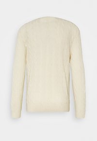 Krämfärgad kabelstickad tröja med långa ärmar, rund halsringning och ribbat nederkant. Texturen har intrikata mönster genom hela tyget.