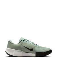 Ανοιχτό πράσινο Nike sneaker χαμηλού προφίλ με μαύρο σήμα, λευκή ενδιάμεση σόλα, υφή στην περιοχή των δαχτύλων και μαύρη εξωτερική σόλα σε λευκό φόντο.