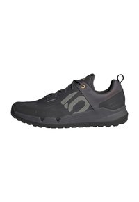 Černá atletická bota s texturovaným povrchem, která má logo na boku, zlaté očky, poutko a gumovou podrážku pro trakci.