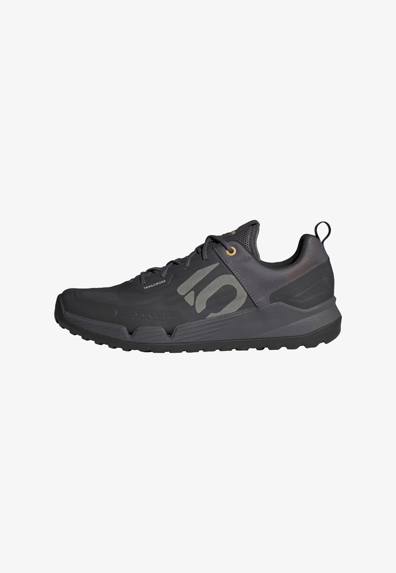 Černá atletická bota s texturovaným povrchem, která má logo na boku, zlaté očky, poutko a gumovou podrážku pro trakci.
