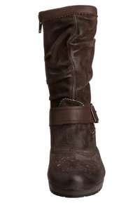 Bota alta de ante marrón con un diseño arrugado, que incluye una amplia correa y detalle de hebilla alrededor del tobillo, superficie texturada y suela plana.