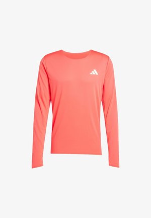 Langærmet atletisk skjorte i lys koral, lavet af glat, letvægtsstof, med et hvidt logo på øverste venstre side.