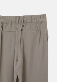 Pantalons gris clair avec un waistband élastique, des poches latérales et deux poches arrière. Le tissu semble lisse avec une texture douce.