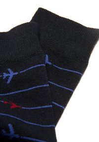 Calcetines negros con rayas horizontales azules y pequeños patrones de aviones rojos y azules sobre un fondo blanco.