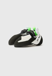 Climbing shoes feature a white and black synthetic upper, textured rubber sole, and adjustable straps with green and white pull tabs.