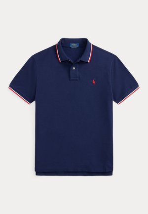 Námornícka modrá Polo Ralph Lauren košeľa s krátkym rukávom s červeným a bielym lemovaním na golieri a rukávoch, s červeným vyšívaným logom na hrudi.