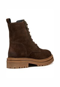 Stivaletto in suede marrone con finitura texturizzata, dotato di zip laterale, lacci frontali e suola in gomma chunky.
