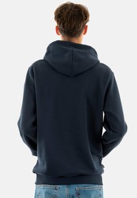 Navyblauwe hoodie van zacht materiaal met een grote capuchon en geribde manchetten, met een minimalistisch ontwerp en geen zichtbare logo's of patronen.