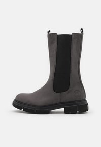 Stivale alla caviglia in suede grigio con pannelli laterali elasticizzati, punta arrotondata e suola in gomma con dettagli incisi. Marchio laterale.