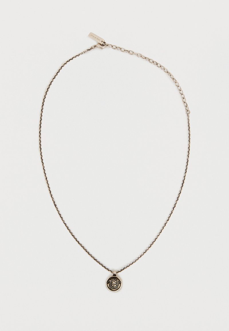 Λεπτό ασημένιο κολιέ με αλυσίδα, με στρογγυλό μενταγιόν κεφαλής Μέδουσας και ρυθμιζόμενο κούμπωμα σε ανοιχτό φόντο.