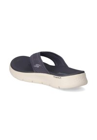 Dark navy flip-flop sandal with a woven strap design and a flexible white sole. Notable textured footbed for comfort and stability.