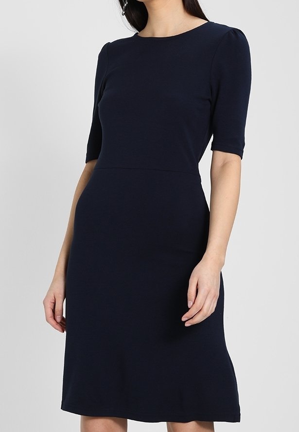 Marinblå klänning i stretchmaterial, med rundad halsringning, korta ärmar och en figurnära byst som flarear något vid fållen.