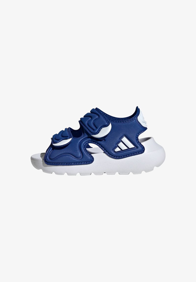 Niebieskie syntetyczne sandały z teksturowanymi nakładkami, białymi akcentami oraz ząbkowanymi paskami na grubej białej podeszwie. Posiadają logo Adidas.