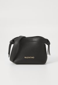 Borsa a tracolla in pelle nera con finitura texturizzata, caratterizzata da un logo dorato "VALENTINO" e un dettaglio con cinturino annodato. Design compatto.