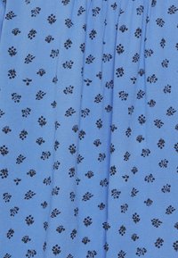 Blauer Stoff mit einem verstreuten schwarzen Blumenmuster. Die Textur ist glatt und hat vertikale Falten.