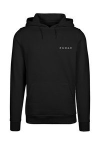 Sweatshirt à capuche noire en tissu doux ; il présente une poche avant et un texte brodé "TRUST" en blanc sur la poitrine.