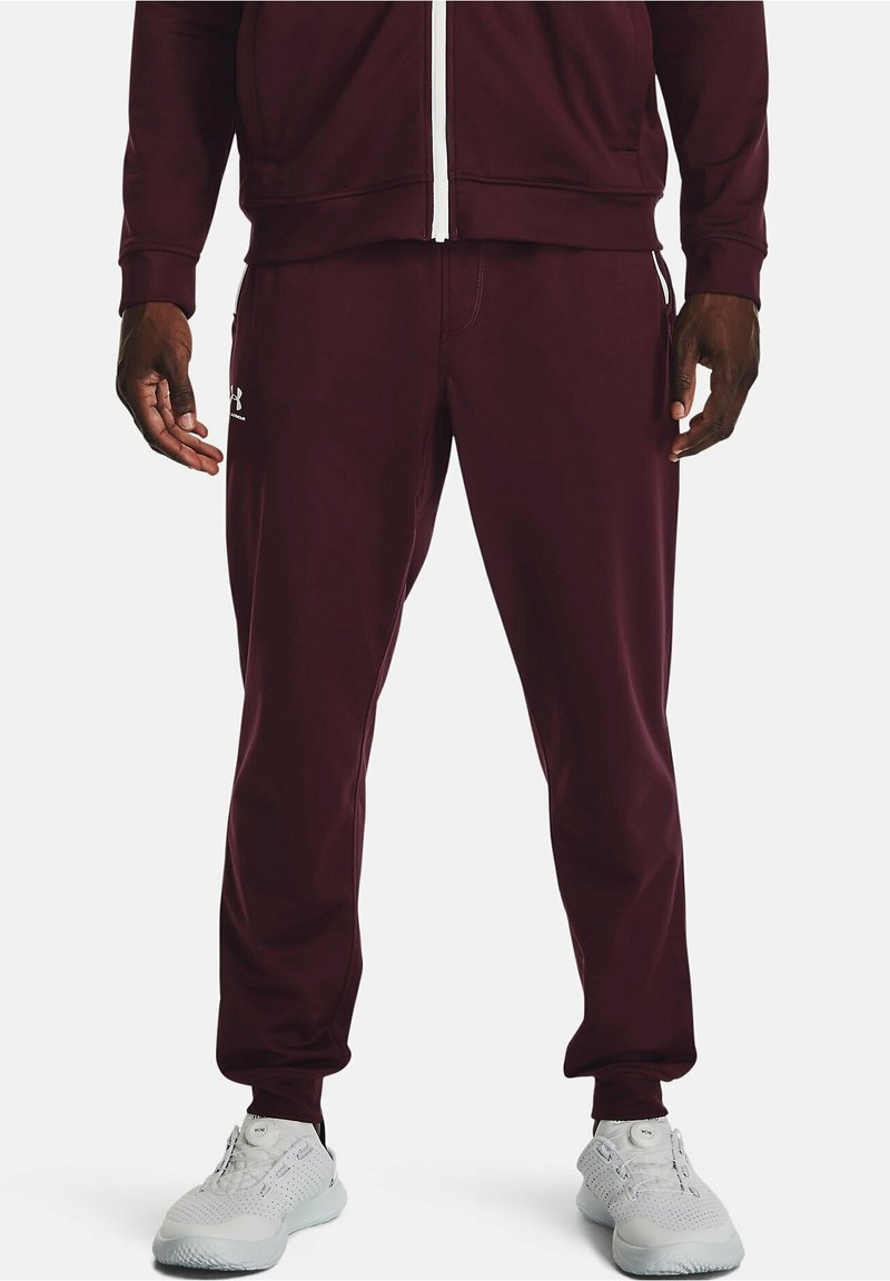 Chándal atlético color burdeos con chaqueta con cremallera y pantalones. Presenta una textura suave, cinturilla elástica y detalles de logotipo en blanco. Calzado blanco.